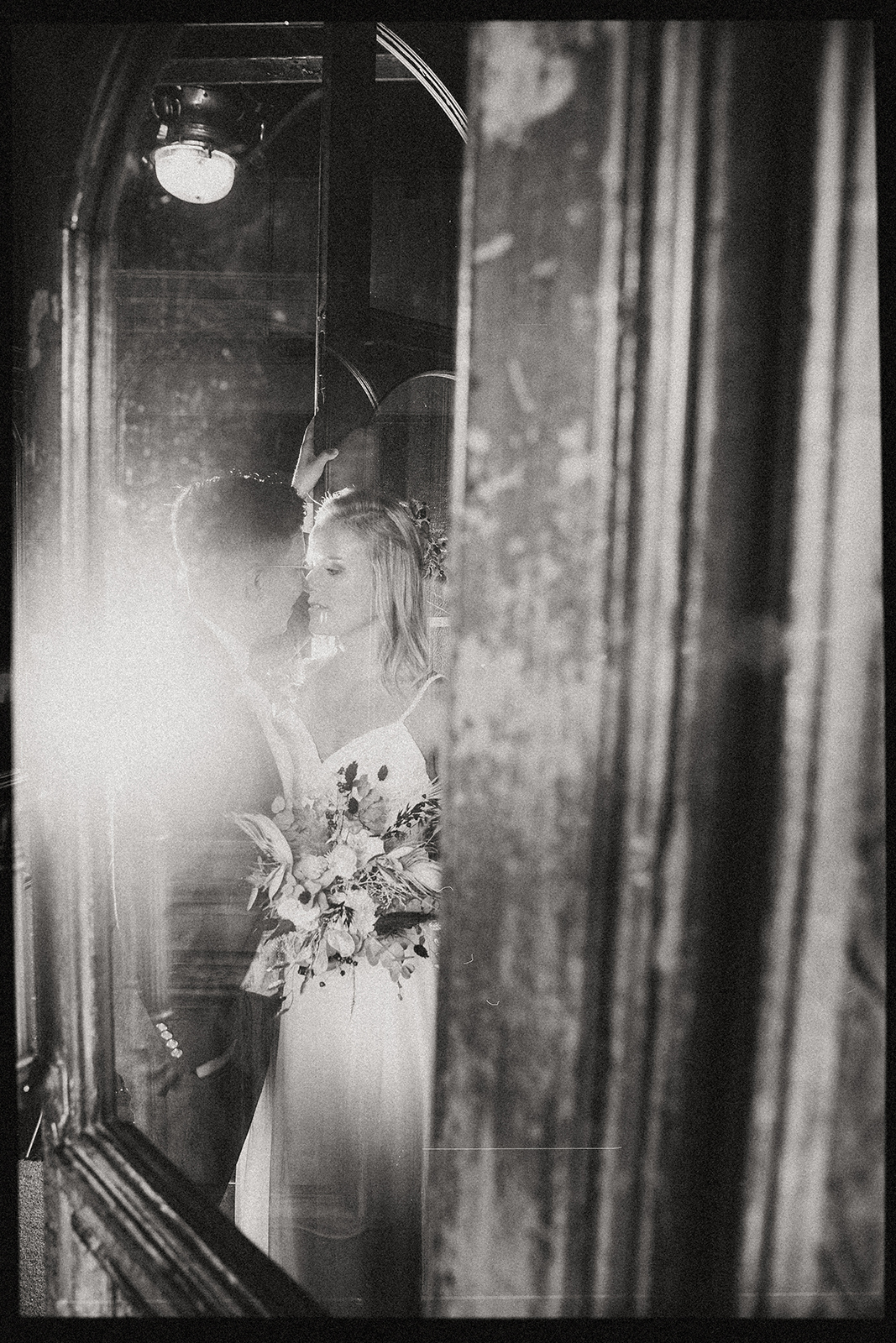 Hochzeitsreportage Brautpaar Schwarzweiss mit Spiegelung und Brautstrauss authentische Hochzeitsfotografie Schweiz Fotoatelier Mariano