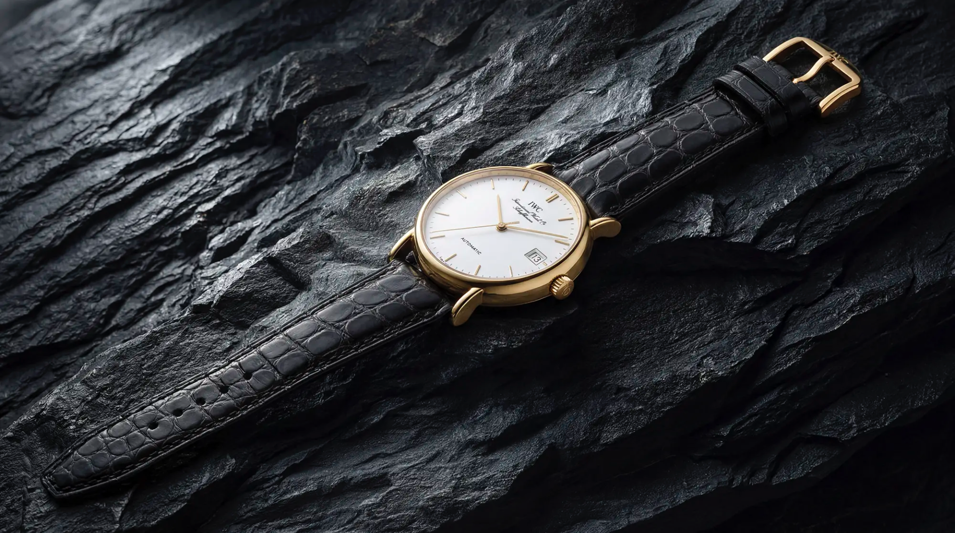 Luxus-Armbanduhr mit schwarzem Lederarmband auf dunklem Naturstein fotografiert für hochwertige Produktfotografie in der Schweiz.