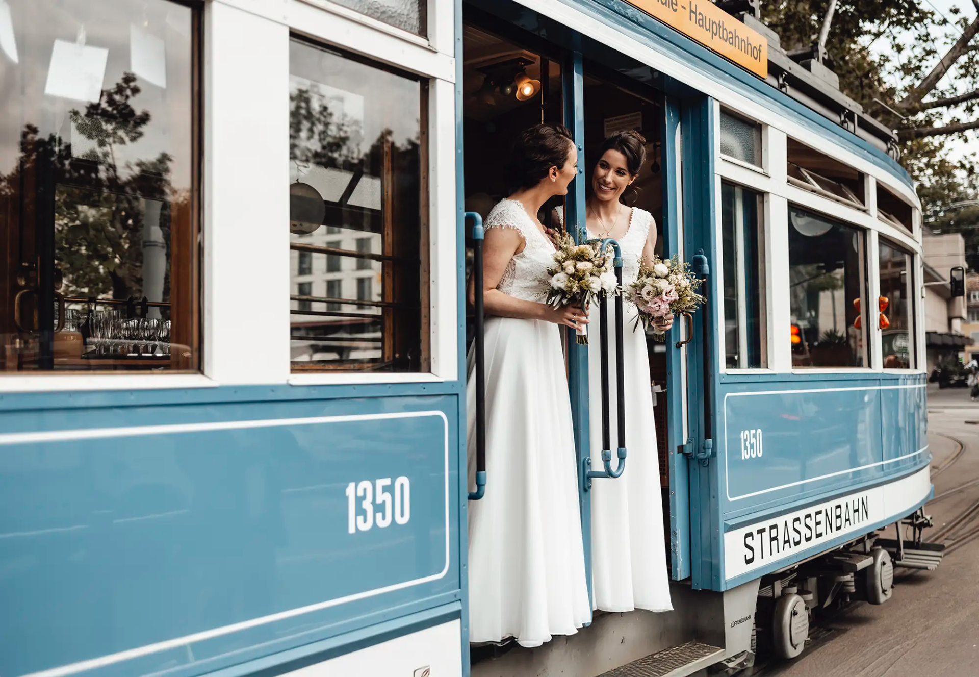 Brautpaar mit Brautsträussen im Eingang eines historischen Trams in Zürich