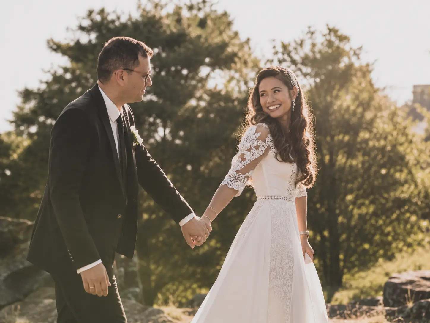 Hochzeitspaar geht Hand in Hand durch den Garten von Schloss Meggenhorn
