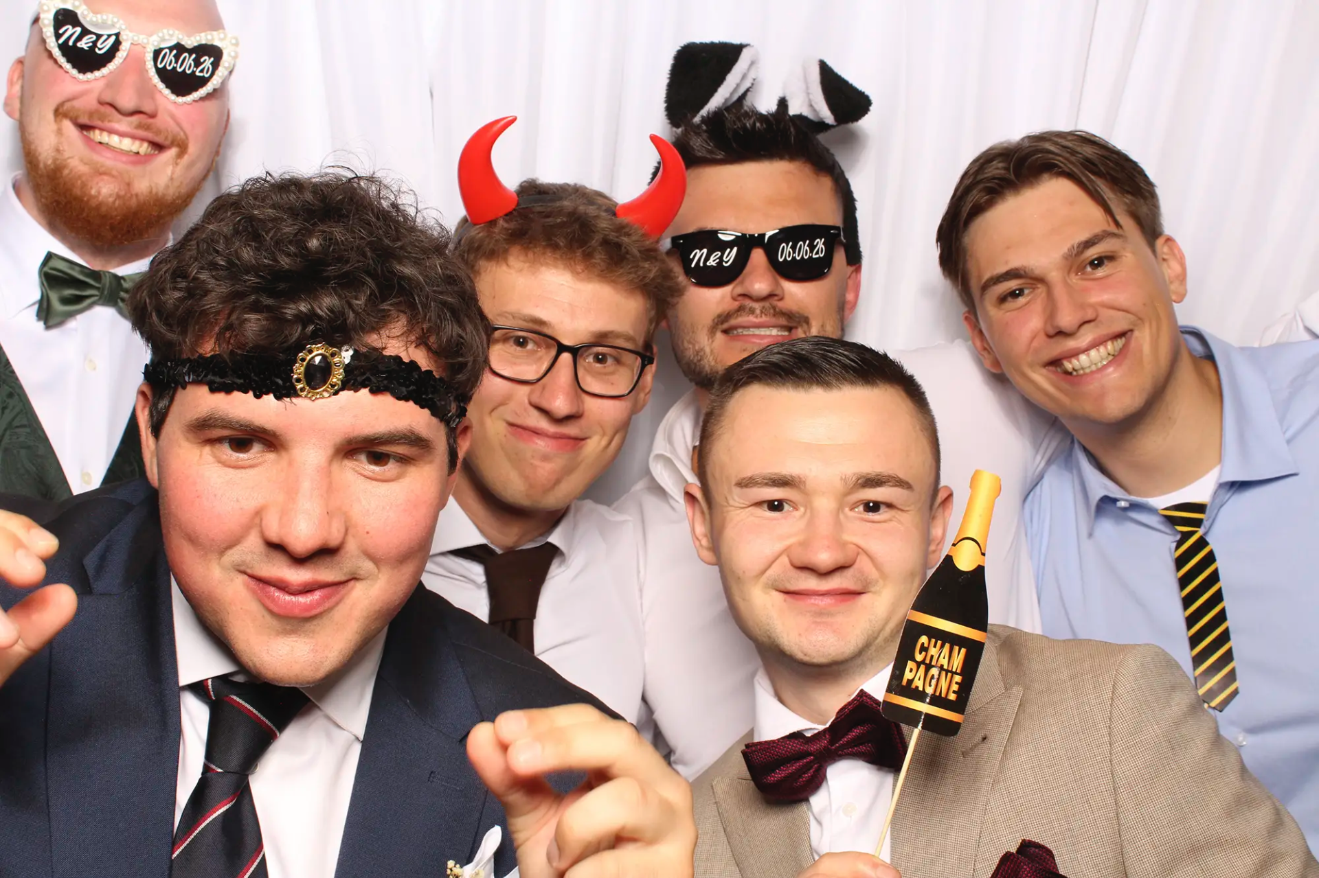 Gäste posieren mit Accessoires an der Selfiebox bei der Hochzeit in Hertenstein