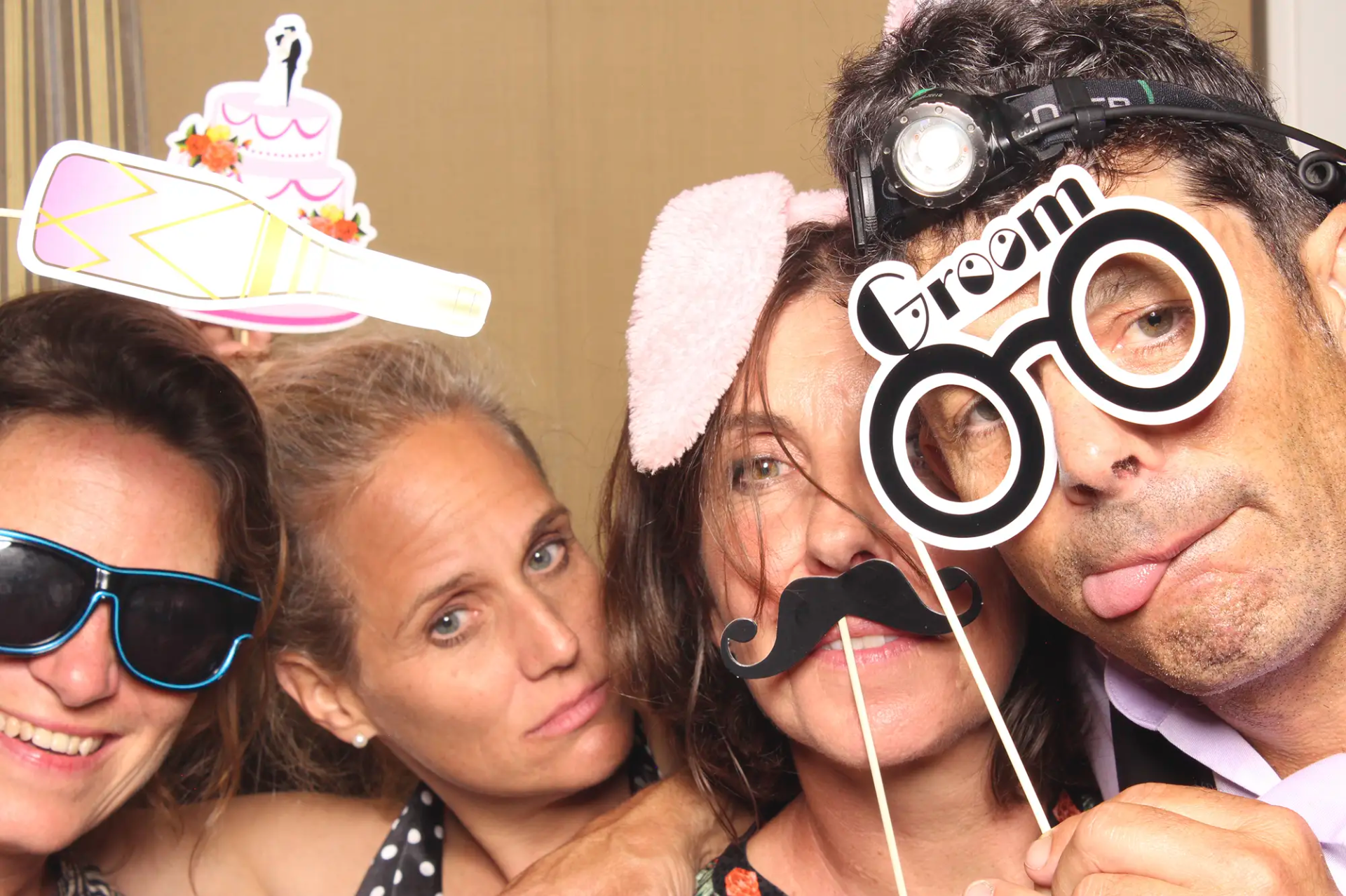 Gäste posieren mit Requisiten an der Selfiebox bei der Hochzeit in der Villa Honegg.