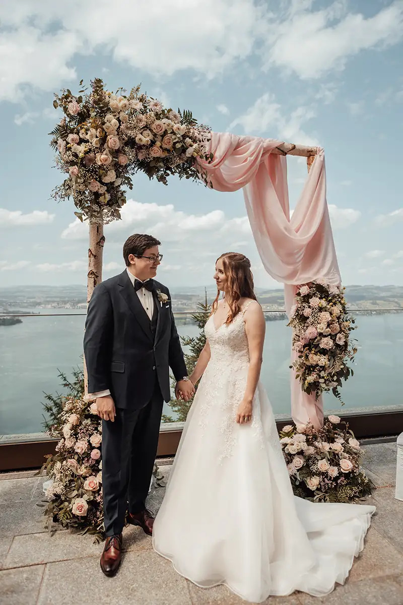 Tanja und Patrice vor dem floralen Traubogen auf der Terrasse des Bürgenstock Resort.