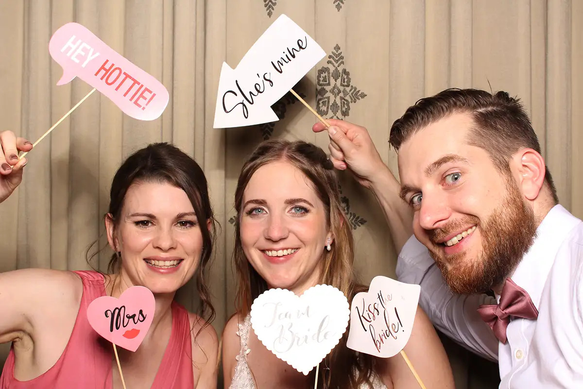 Tanja mit Gästen und lustigen Schildern in der Selfiebox während der Hochzeitsfeier im Bürgenstock Resort.