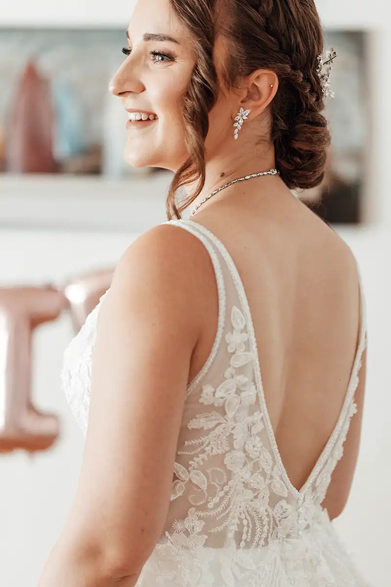 Braut Ramona beim Getting Ready mit Blick zum Fenster vor der Hochzeit