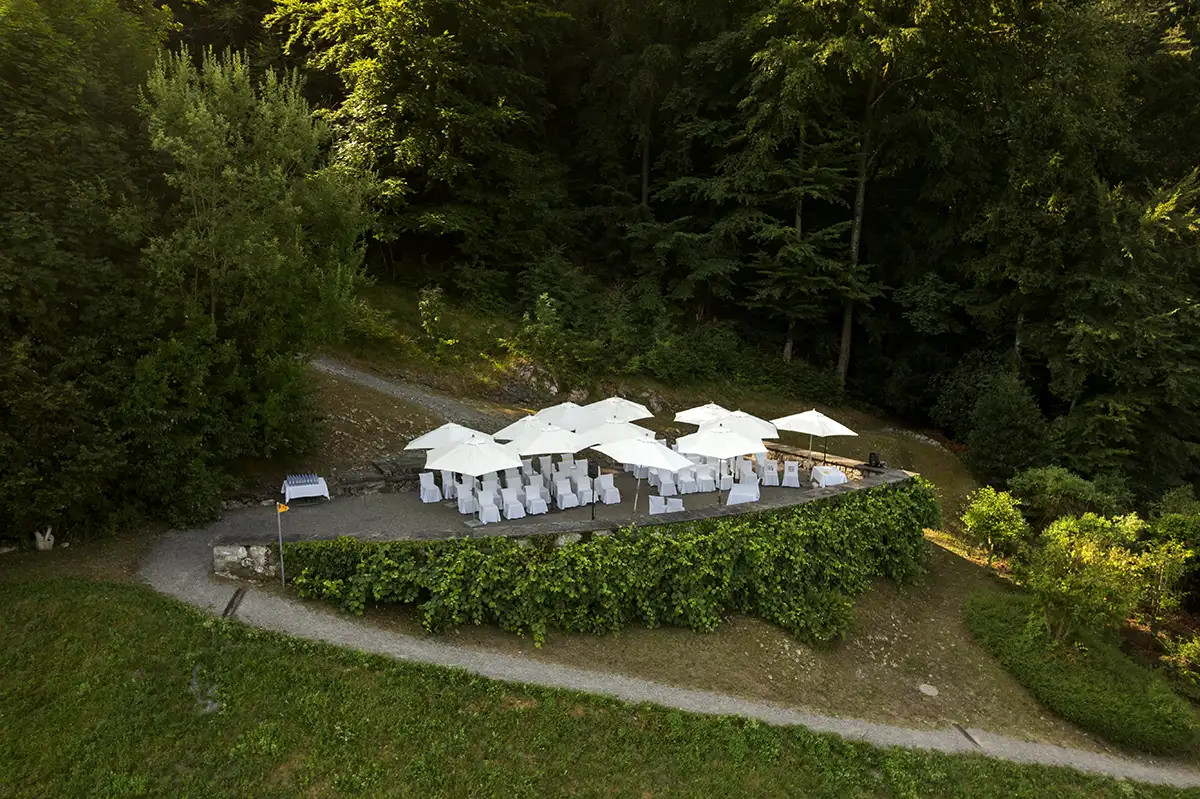 Drohnenaufnahme der Hochzeitslocation Hotel FloraAlpina mit Festbereich im Gruenen