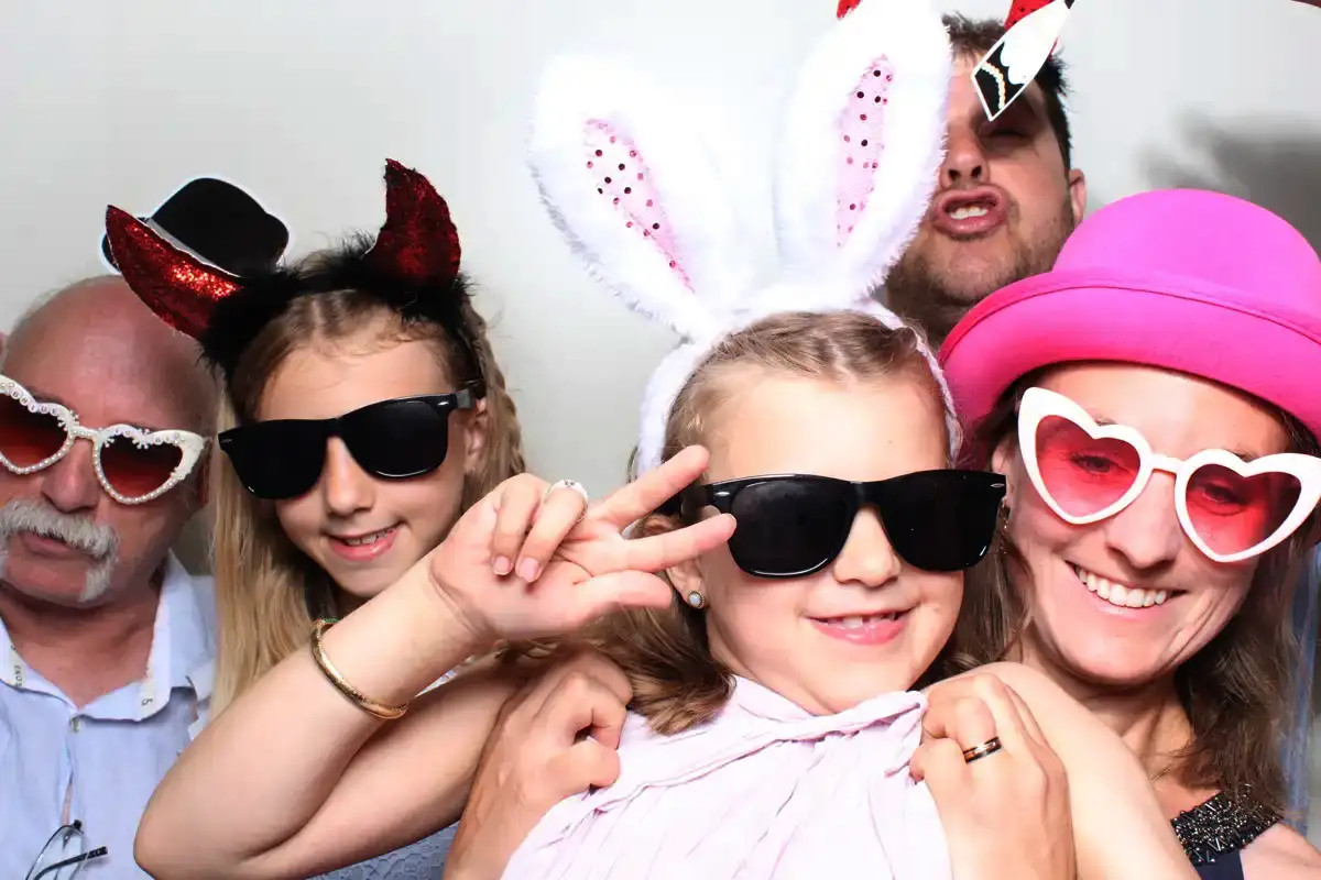 Kinder und Gäste mit Requisiten in der Selfiebox bei der Hochzeit in Luzern.