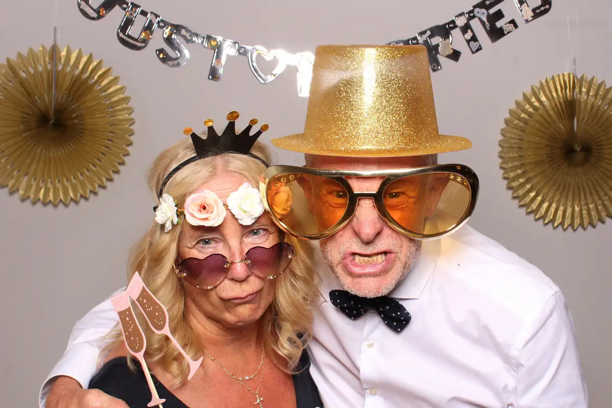 Selfiebox-Foto von Hochzeitsgästen mit goldenen Accessoires und lockerer Abendstimmung.