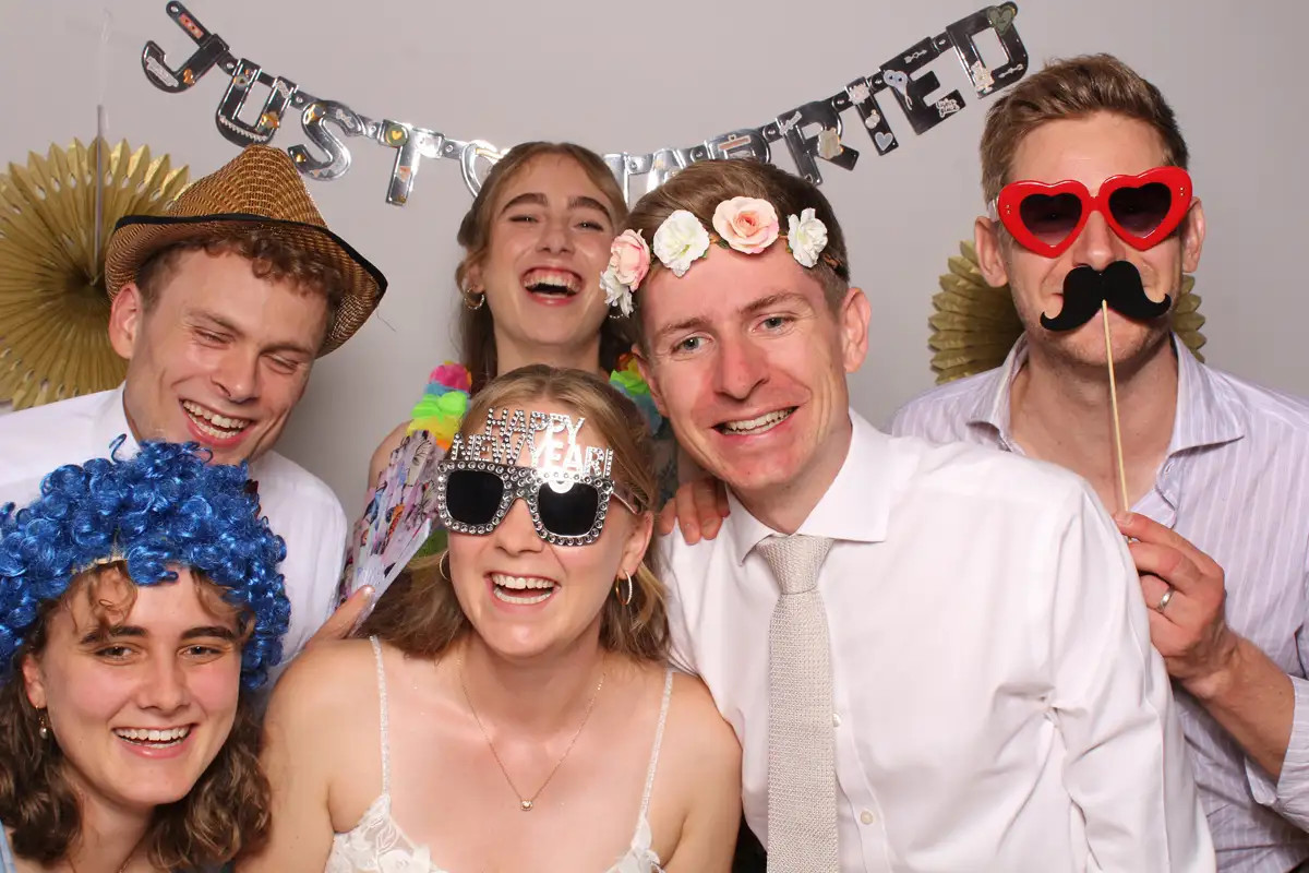 Fröhliche Gäste in der Selfiebox bei der Hochzeit auf Rigi Kulm mit lustigen Requisiten.