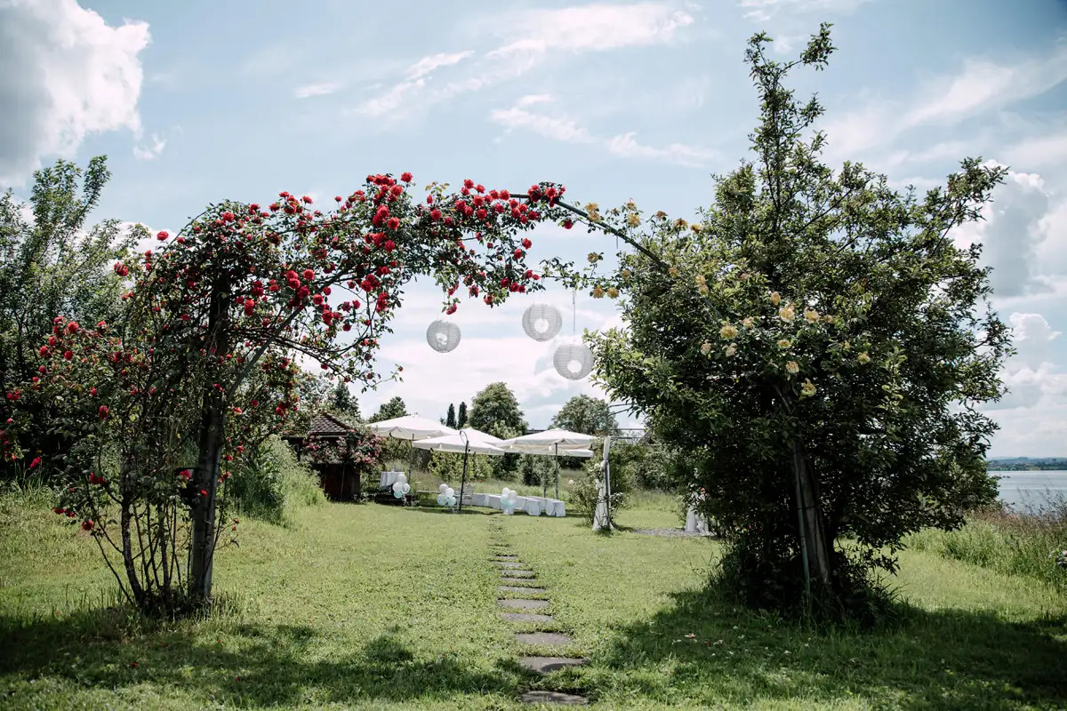 Blumengeschmückter Bogen für die freie Trauung im Garten des Biohofs Zug.