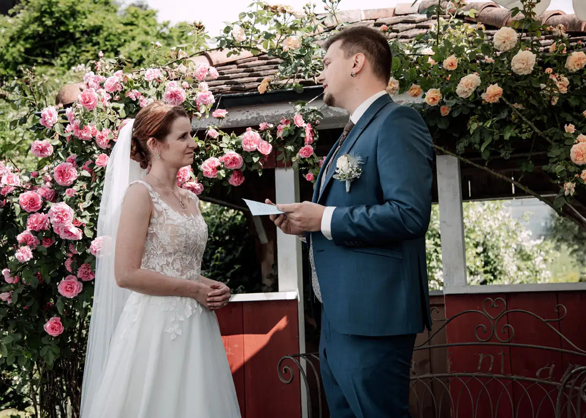 Fabienne und Simon während ihrer freien Trauung unter dem Blumenbogen.